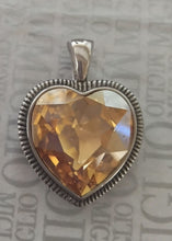 Load image into Gallery viewer, Heart-shaped pendant with a topaz colour crystal on a textured background
