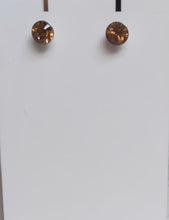 Load image into Gallery viewer, Pair of brown stud earrings on a white card with a blurred background