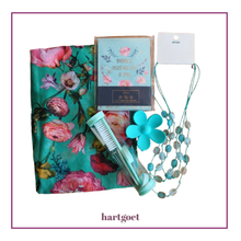 Load image into Gallery viewer, A Hartgoet gift set featuring a teal floral scarf, a notebook, a turquoise mini manicure set, a daisy jaw hair clip and a beaded necklace on a white background with a purple border.