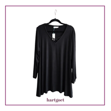 Load image into Gallery viewer, A black long-sleeve V-neck top with a criss-cross detail at the neckline, hanging on a black hanger against a white background with a purple border and 'hartgoet' text below.