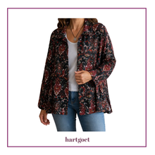 Load image into Gallery viewer, A woman wearing a long-sleeve button-up jacket with a dark red, black, and brown paisley pattern over a white top and blue jeans, shown against a white background with a purple border. The brand name 'hartgoet' is printed at the bottom.