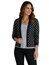 Load image into Gallery viewer, A woman wearing a black cardigan with white polka dots over a light gray tank top and black pants, standing against a white background.