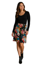 Load image into Gallery viewer, A woman modeling a black long-sleeve top and a black skirt with a colorful floral print, paired with black ankle boots, against a plain white background.