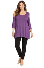 Load image into Gallery viewer, A woman modeling a purple cold-shoulder tunic top with three-quarter sleeves, paired with black pants and beige heels, against a white background.