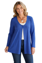 Load image into Gallery viewer, A smiling blonde woman wearing purple long-sleeve open-front cardigan over a white top and dark blue jeans, standing against a white background.