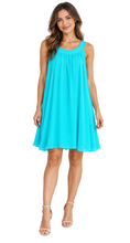 Load image into Gallery viewer, A woman modeling a sleeveless turquoise blue shift dress , paired with beige strappy high-heeled sandals, set against a plain white background.
