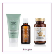 Load image into Gallery viewer, Three SH'ZEN natural products arranged side by side on a white background: a pale green tube of Energising Cream, an amber bottle of Circulate Concentrate, and an amber bottle of Leg Energiser with Cramp Bark. A hartgoet logo appears below the products inside a thin magenta border.