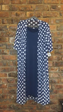 Load image into Gallery viewer, Long navy dress with navy and white polka dots mesh jacket on a hanger against a brick wall
