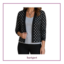 Load image into Gallery viewer, A woman wearing a black cardigan with white polka dots over a light gray tank top and black pants, shown against a white background with a purple border. The brand name 'hartgoet' is printed at the bottom.
