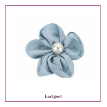 Load image into Gallery viewer, Light blue flower-shaped hair clip with a pearl center on a white background.  
