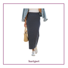 Load image into Gallery viewer, A model wearing a navy blue and white horizontally striped maxi skirt, styled with a light blue denim jacket, white sneakers, and a straw tote bag. The brand name 'hartgoet' is printed at the bottom of the image.
