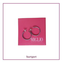 Load image into Gallery viewer, Silver hoop earrings on a pink card with 'Miglio' branding
