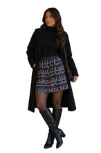 Load image into Gallery viewer, Model wearing an aztec print mini skirt, black top and jacket and black boots, on a white background
