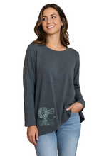 Load image into Gallery viewer, A woman wearing a dark gray long-sleeve top with a white windmill graphic near the lower left front, paired with light blue jeans, against a plain white background.
