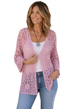 Load image into Gallery viewer, A woman wearing a light pink open-front lace cardigan over a white top and blue jeans, photographed against a plain white background.
