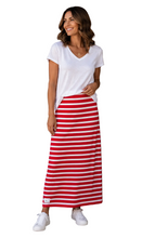 Load image into Gallery viewer, A woman stands against a white background, wearing a white V-neck short-sleeve t-shirt and a red and white horizontally striped maxi skirt, paired with white sneakers.
