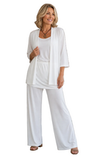 Load image into Gallery viewer, A woman modeling a white outfit consisting of a short-sleeve open-front cardigan, a scoop-neck top, hip skirt and matching pants, standing a white background
