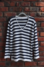 Load image into Gallery viewer, Navy and white jersey on a hanger against a brick wall
