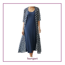 Load image into Gallery viewer, A woman wearing a navy blue dress with a sheer open-front cardigan featuring a white and navy polka dot pattern. The image is presented on a white background with a purple border and the brand name 'hartgoet' printed at the bottom.
