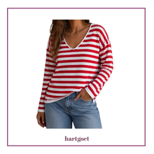 Load image into Gallery viewer, A woman wearing a red and white horizontally striped long-sleeve V-neck top with light blue jeans, shown against a white background with a purple border and the brand name hartgoet below.
