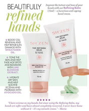 Load image into Gallery viewer, Two white tubes of SH'ZEN The Refining Balm for hands are shown on a white background with marketing text, and a small green balm sample. The left tube is upright and the right tube is tilted to show the applicator opening.
