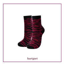 Load image into Gallery viewer, Black and cerise pink zebra-striped socks with 'hartgoet' branding on a white background
